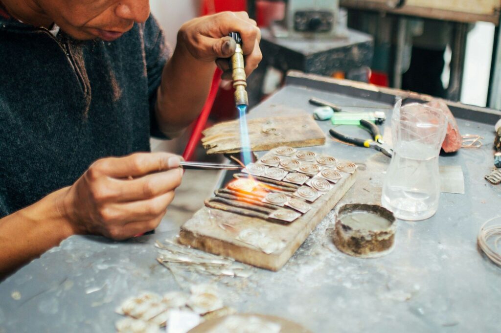 Jeweller soldering metal with a small torch